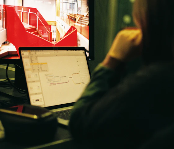 A confident IT architect working on cloud infrastructure diagrams in a modern office.