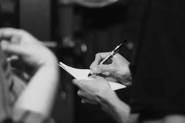 person writing on note