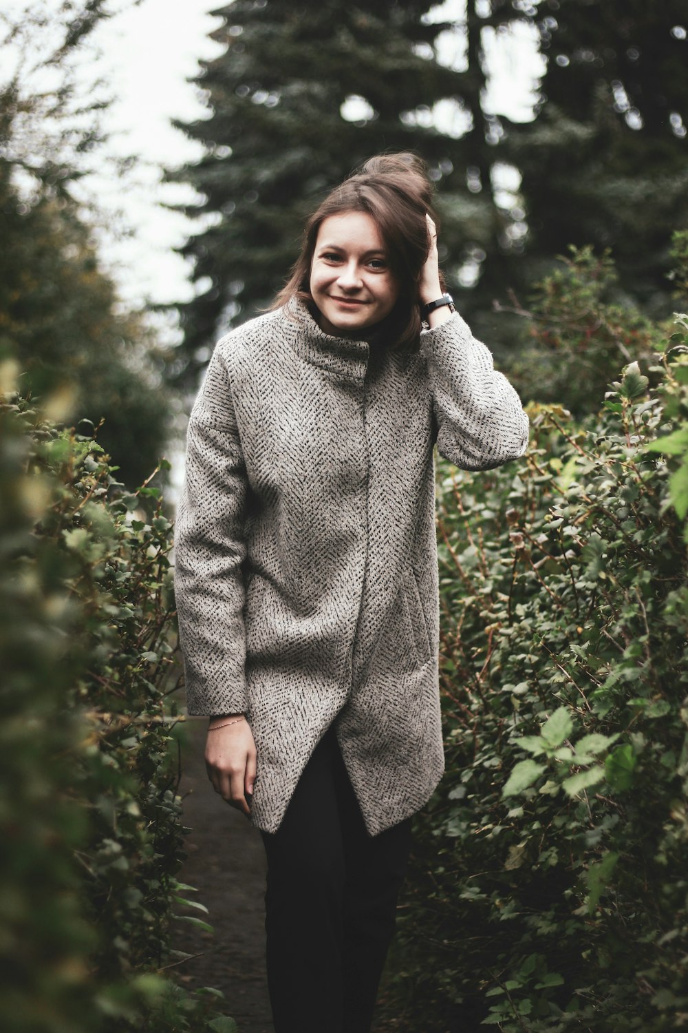 standing woman wearing gray coat