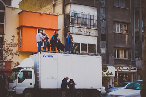 A film crew setting up equipment on a city street.