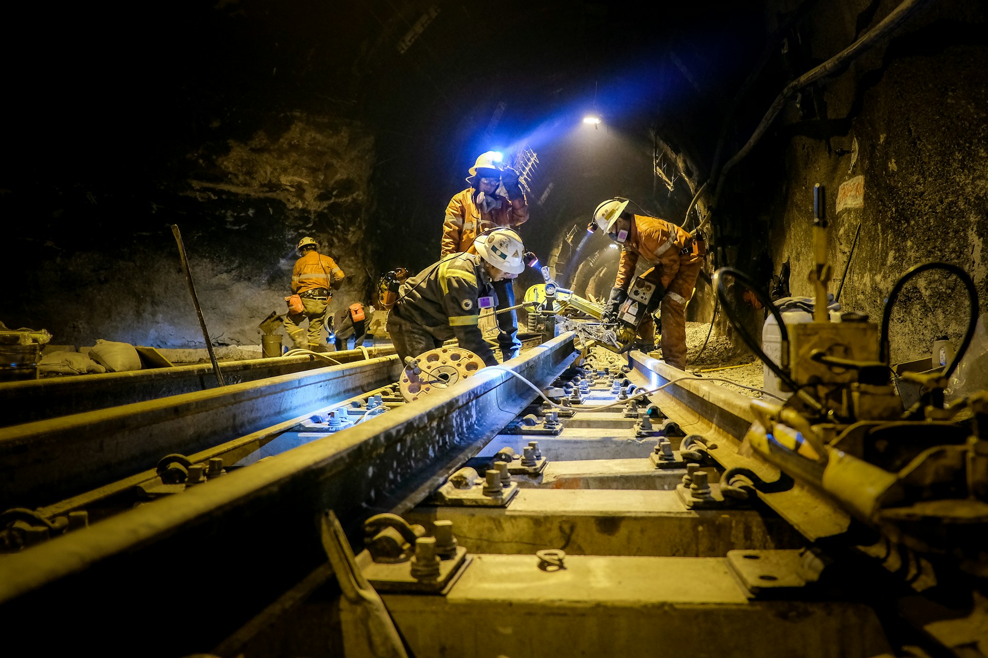 people in safety gear fixing rail road