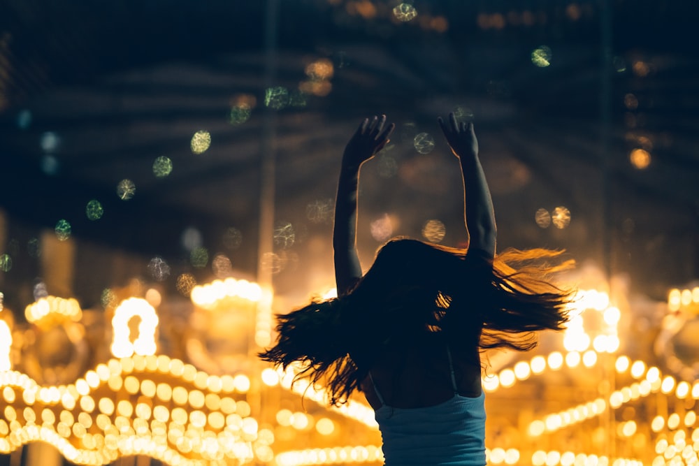 silhouette of woman raising both hands