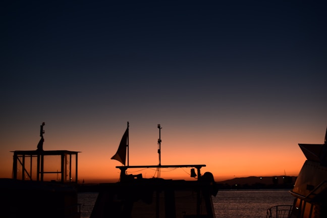 Elegant yacht silhouette outlined against a dark navy gradient ocean backdrop.