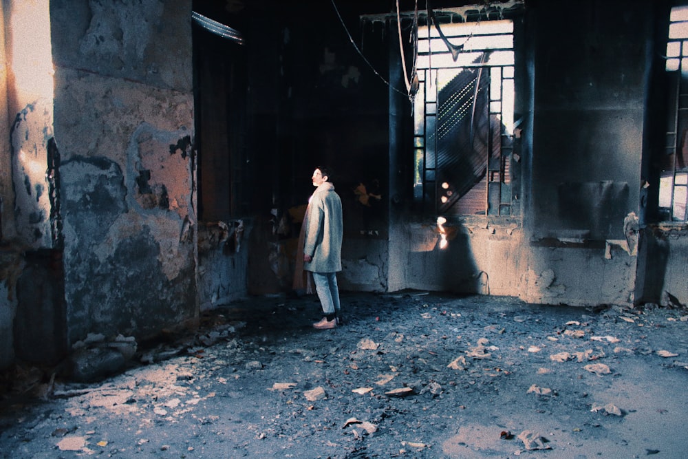 man standing inside burned room