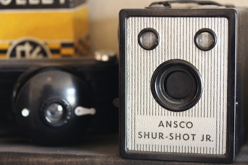 an old camera sitting on top of a shelf