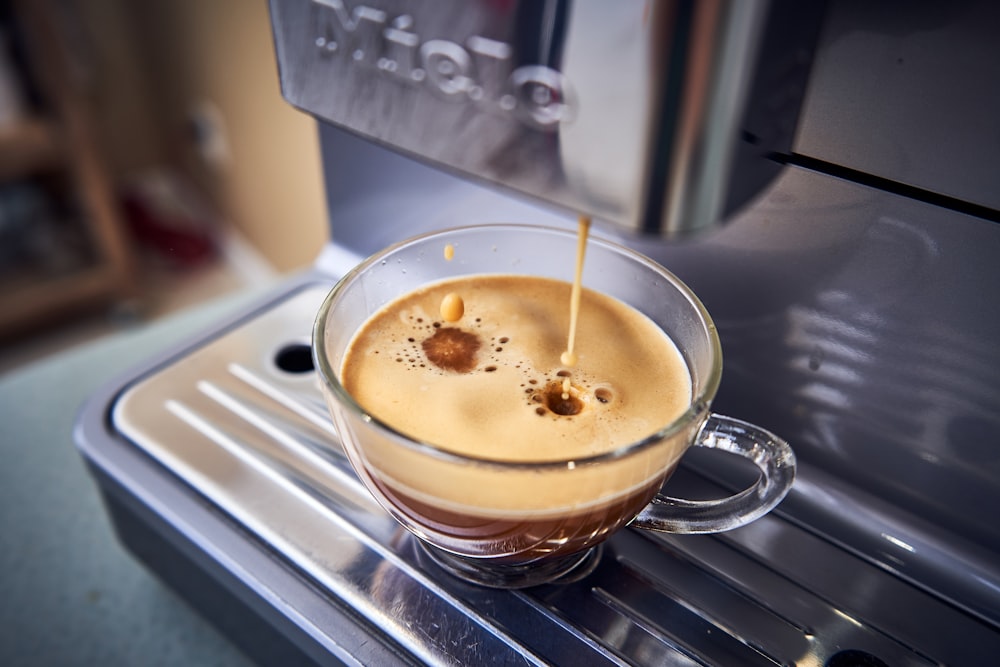 a cup of coffee being filled with liquid