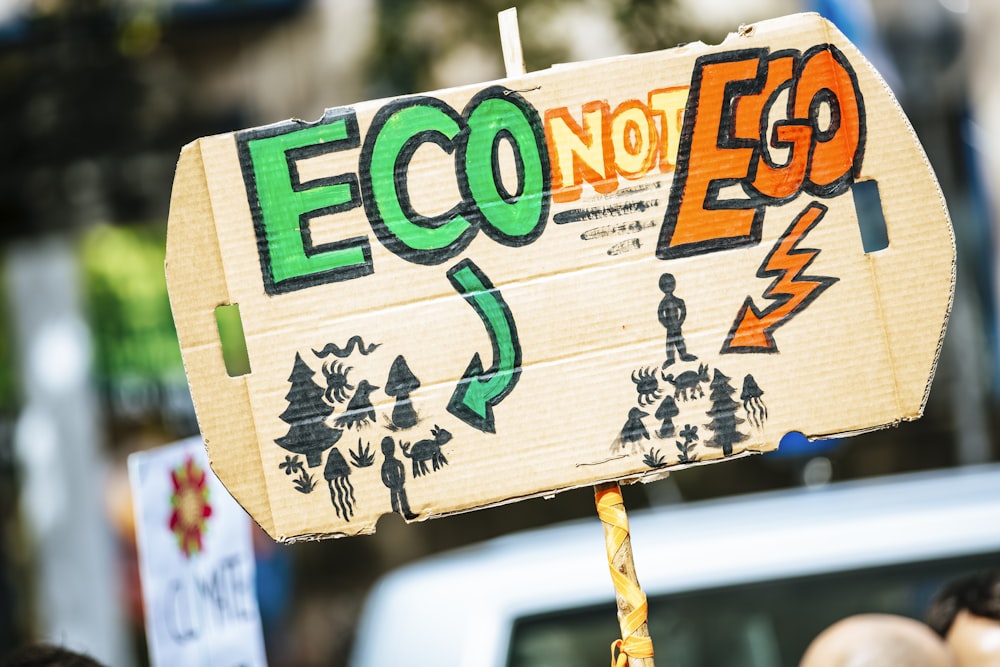 Person, die ein Eco Not Ego-Schild hält