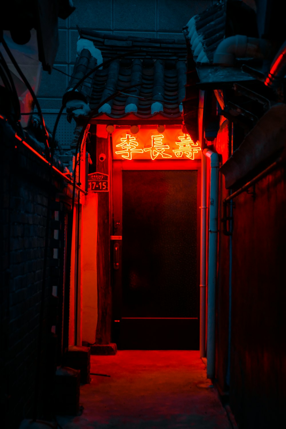 a dark hallway with a neon sign on the door