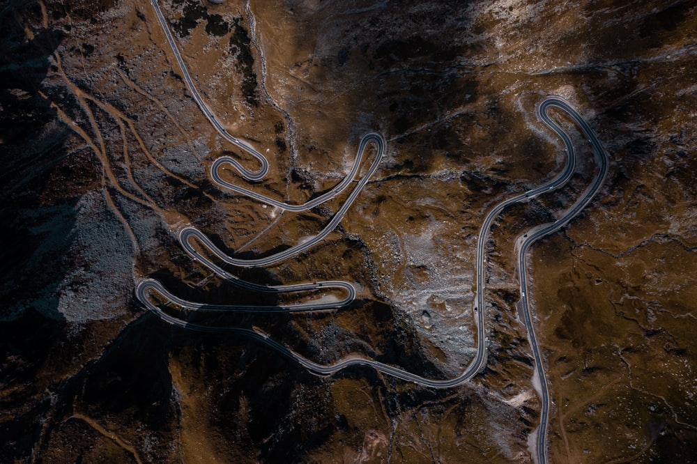 an aerial view of a winding road in the mountains