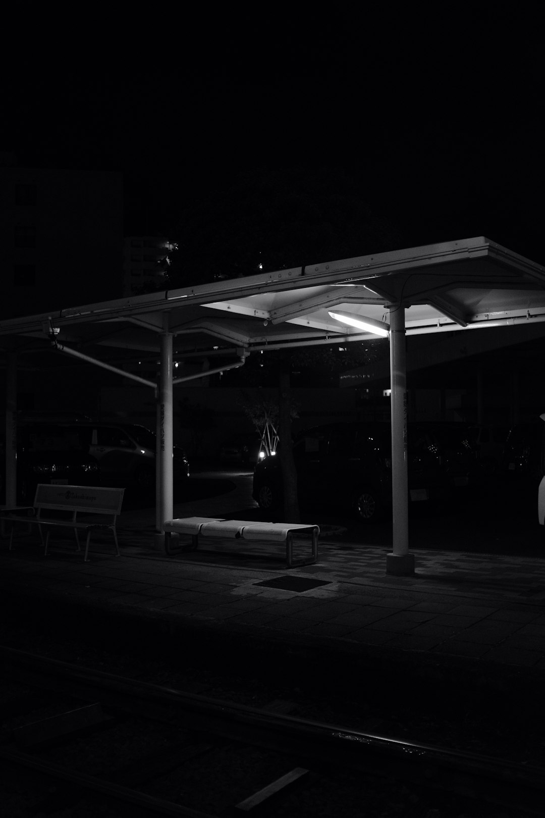 grayscale waiting shed during night