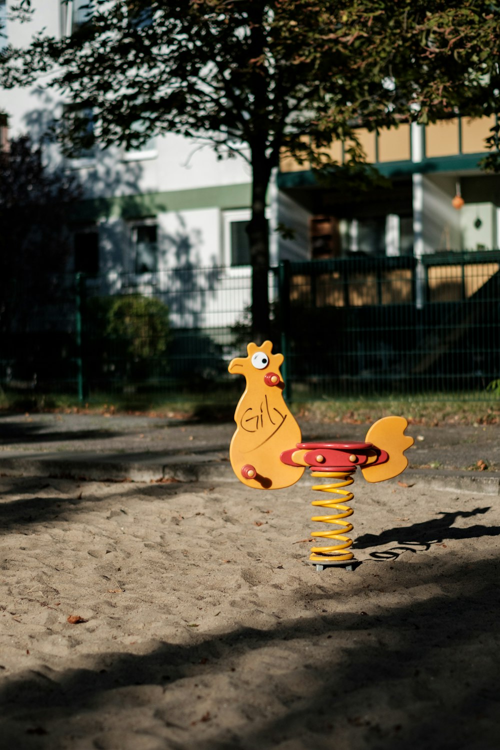 yellow and red metal chicken toy with coil spring