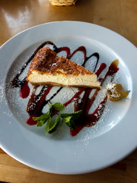 Elegant cheesecake slices beautifully plated with fresh berries and delicate garnishes.