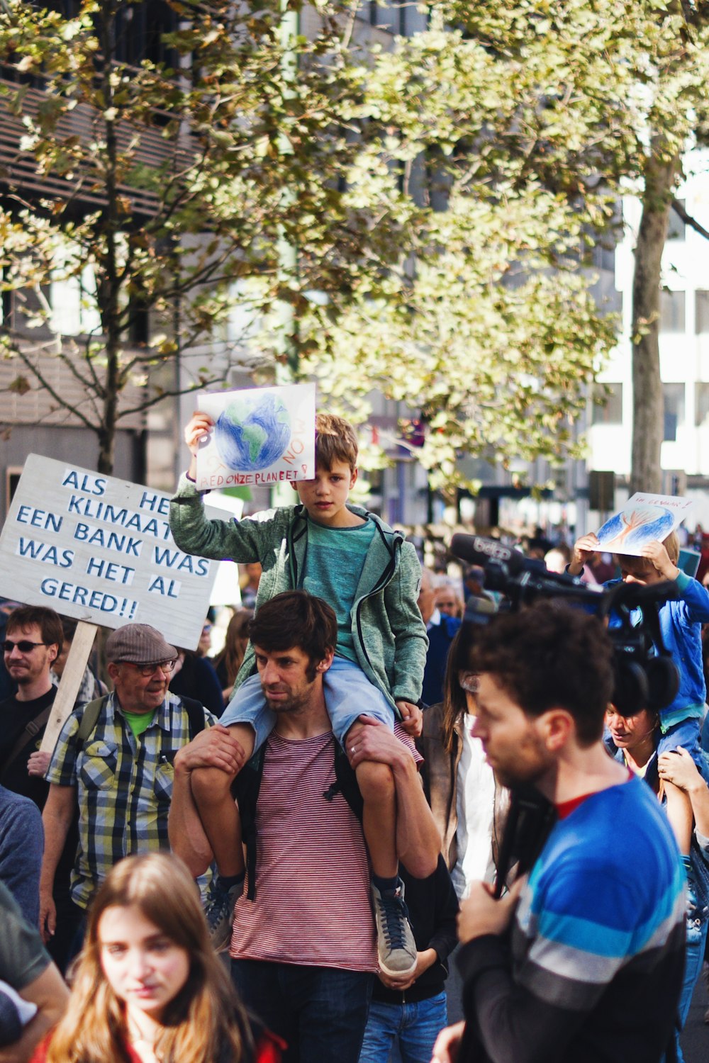 people rallying near tree and building during daytime