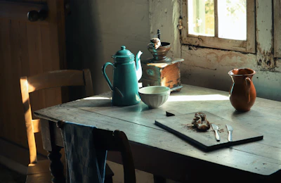 A cozy kitchen nook featuring sunlight streaming over a rustic wooden table set with morning coffee and fresh bread.