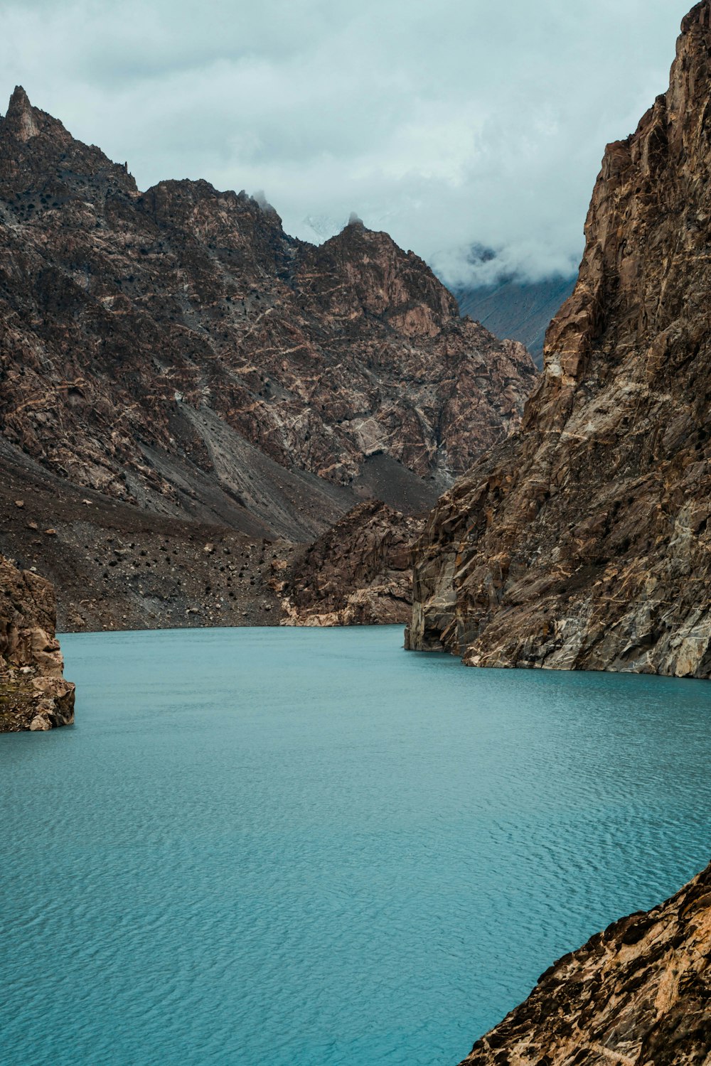 body of water under hills at daytime