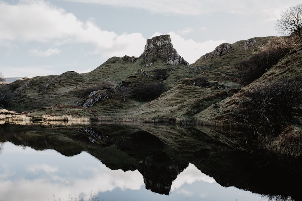 green mountain slope and lake