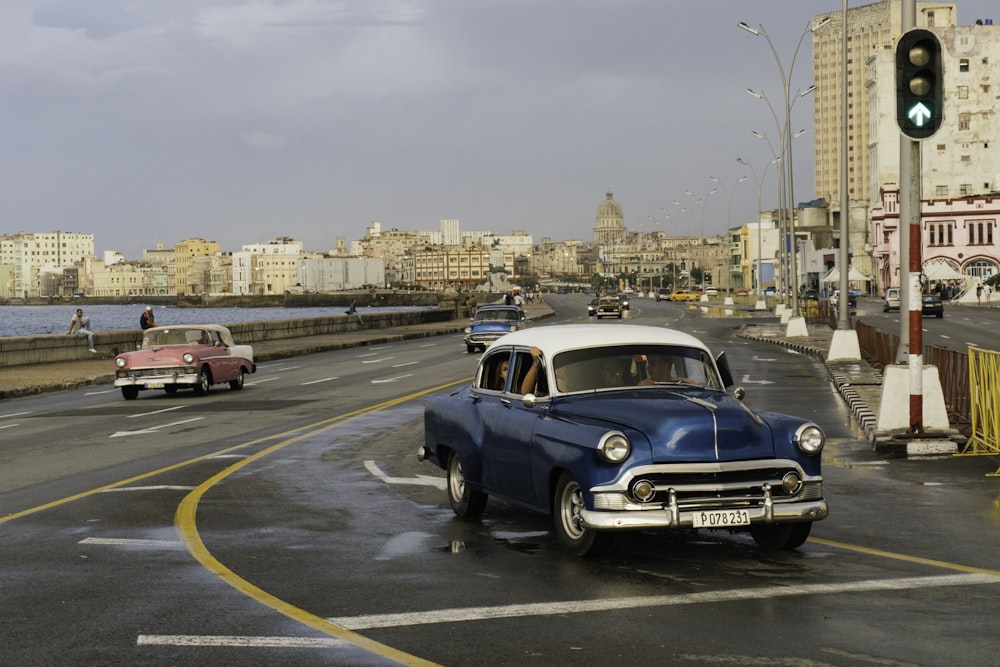 Voiture classique bleue et blanche sur route