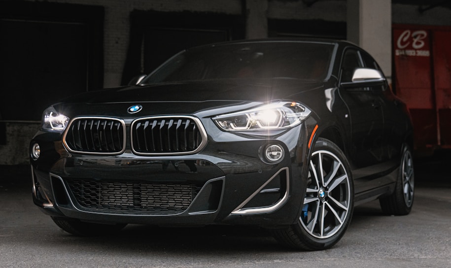 Sleek black BMW parked under soft golden lighting highlighting its contours.