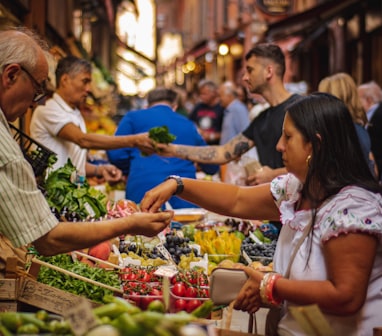 woman wearing white and red blouse buying some veggies