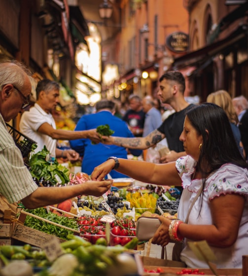 woman wearing white and red blouse buying some veggies