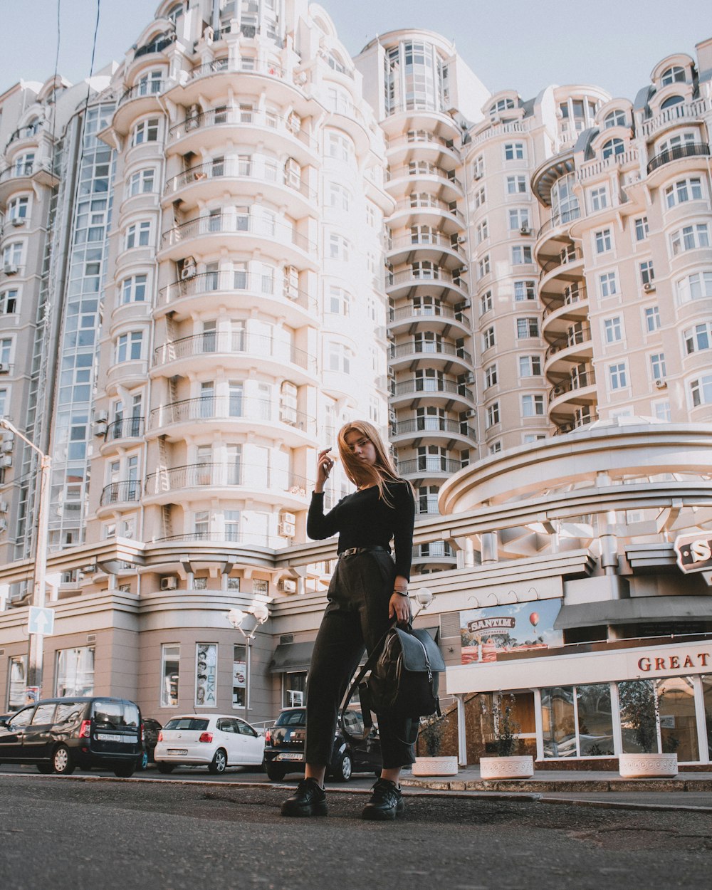 woman standing on road near white building