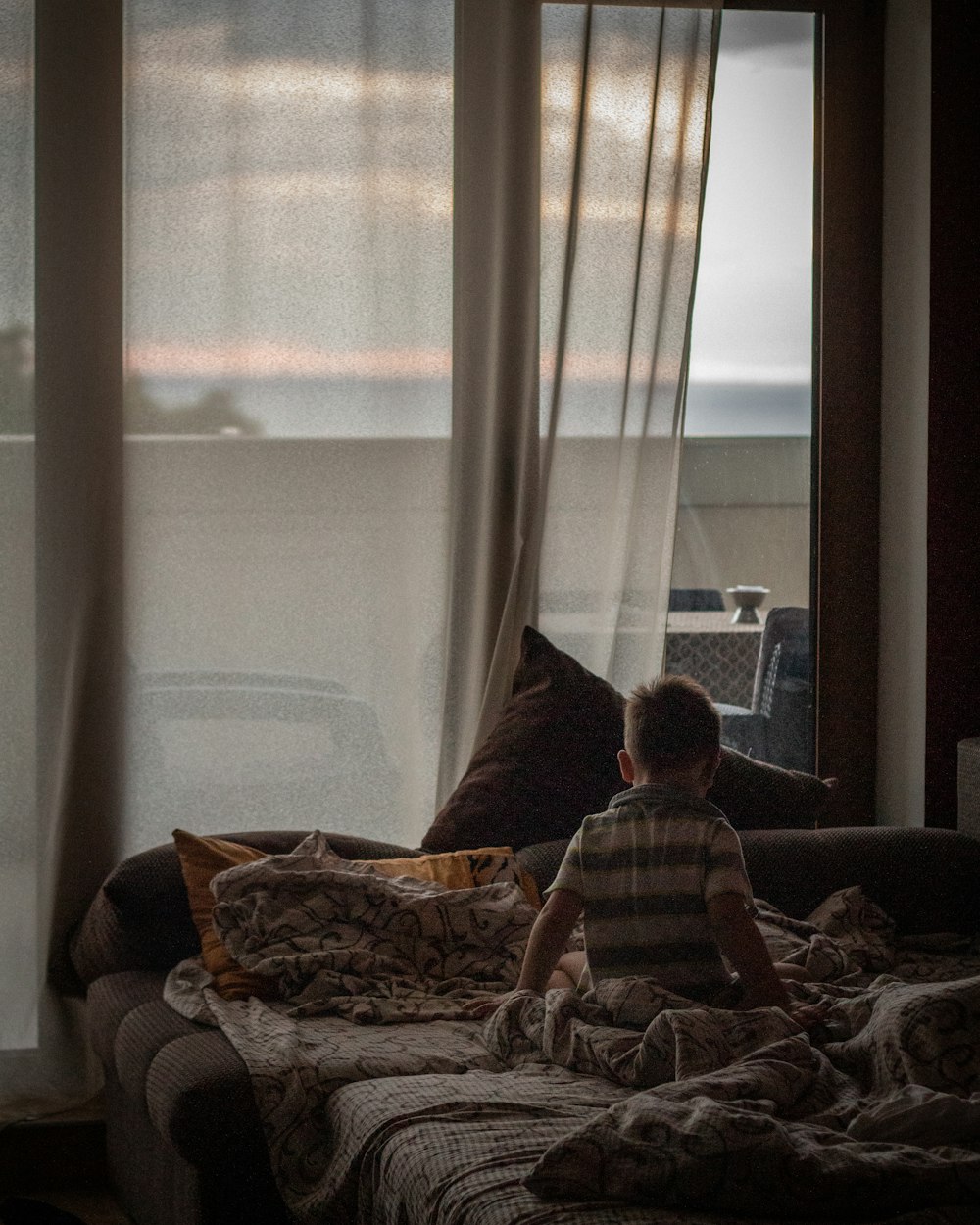 boy on bed near window
