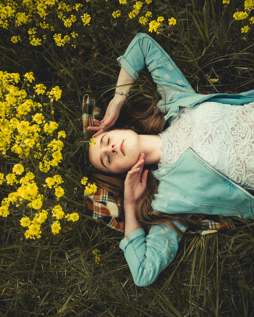 femme couchée sur un champ d’herbe