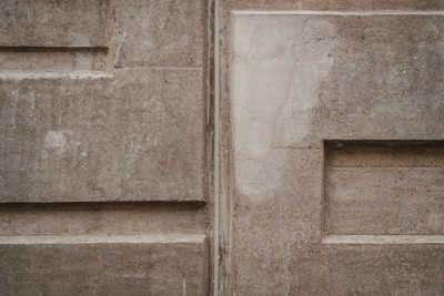 Textured concrete wall featuring a rustic, hand-troweled finish with warm earthy tones.