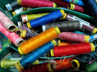 Close-up of colorful kite strings tangled playfully on a wooden spool.