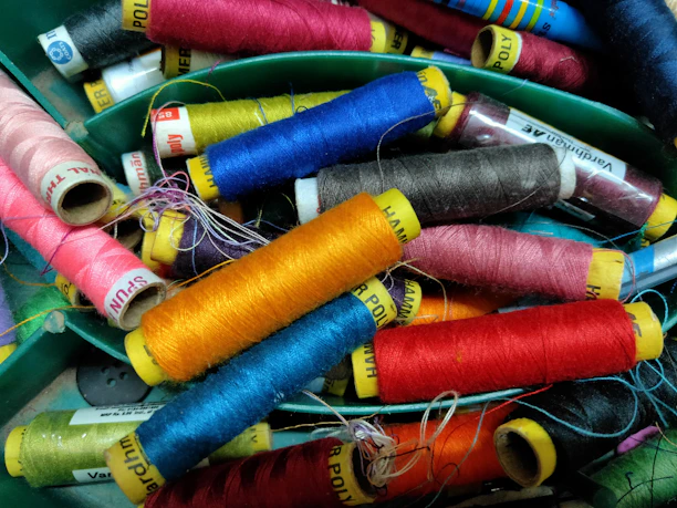Close-up of colorful kite strings tangled playfully on a wooden spool.