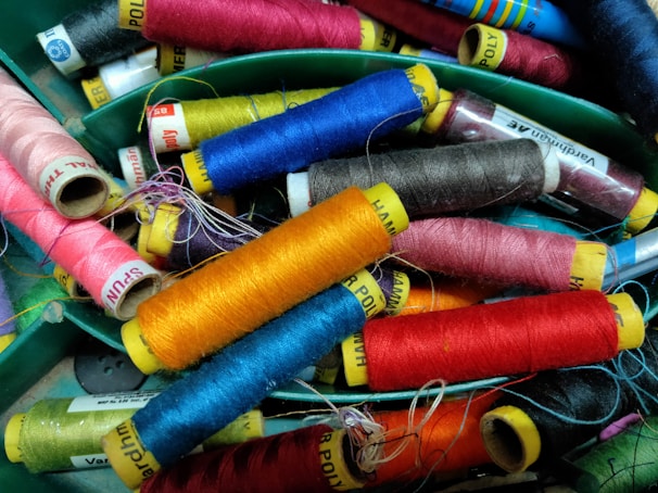 Close-up of colorful kite strings tangled playfully on a wooden spool.