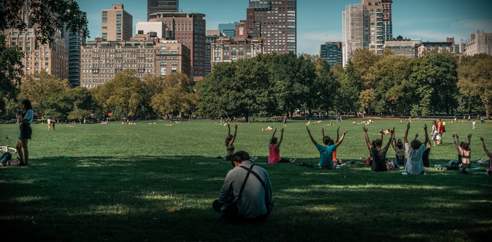 people taking exercise on green grass field