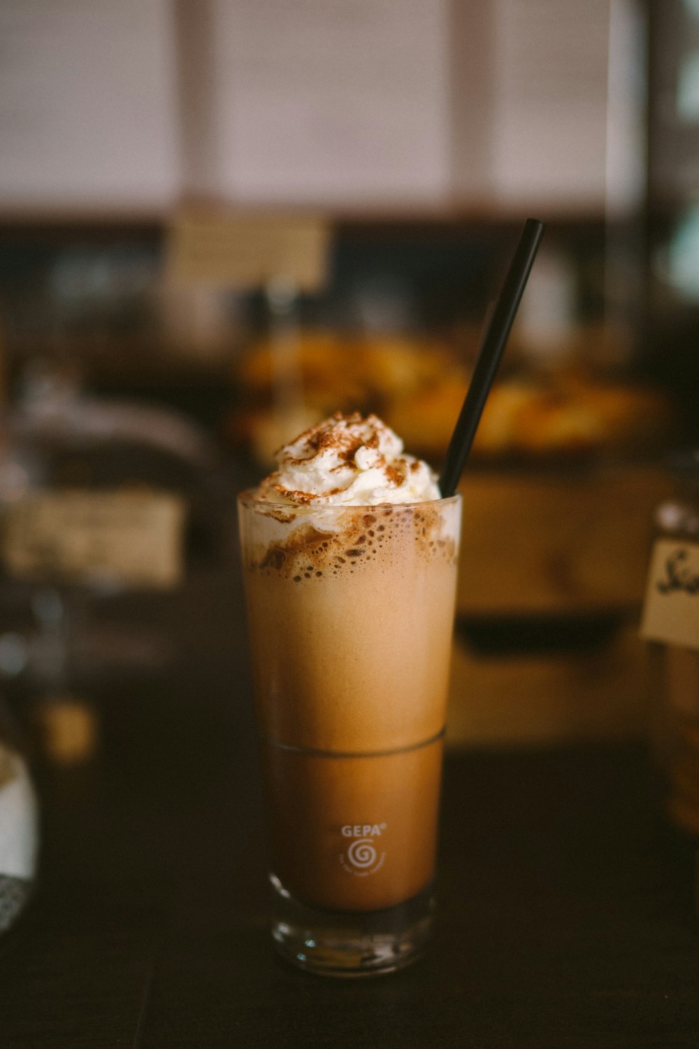 creamy beverage and straw in clear glass cup