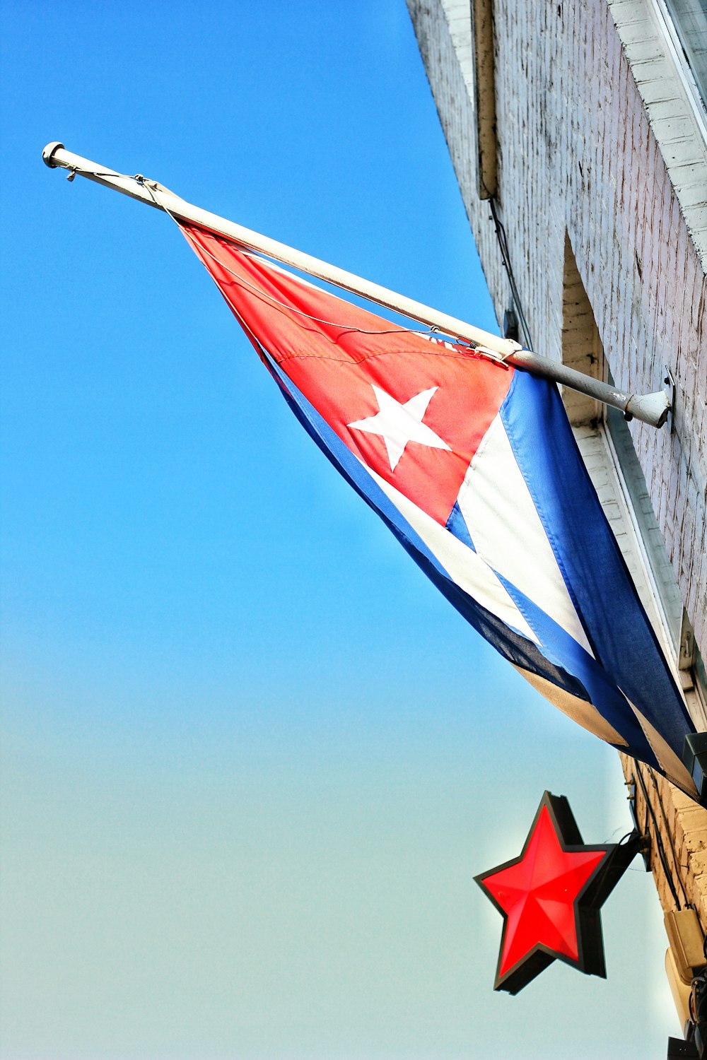 Rote, weiße und blaue Flagge mit Mast an der Wand