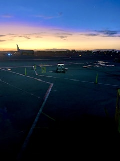 A vibrant photo of an Indonesian airport runway at sunrise, with planes taxiing and ground crew preparing for the day.