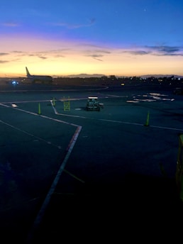 A vibrant photo of an Indonesian airport runway at sunrise, with planes taxiing and ground crew preparing for the day.