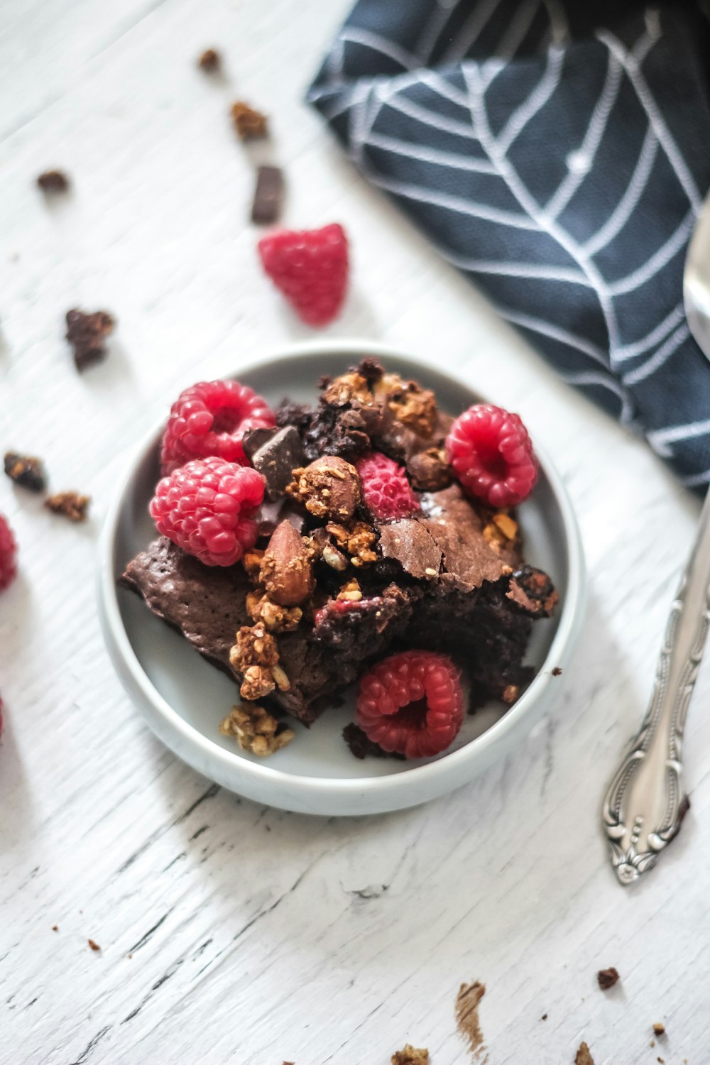 raspberries and chocolate cake in plate on table