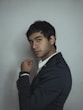 man in black suit beside wall