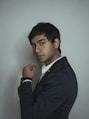 man in black suit beside wall