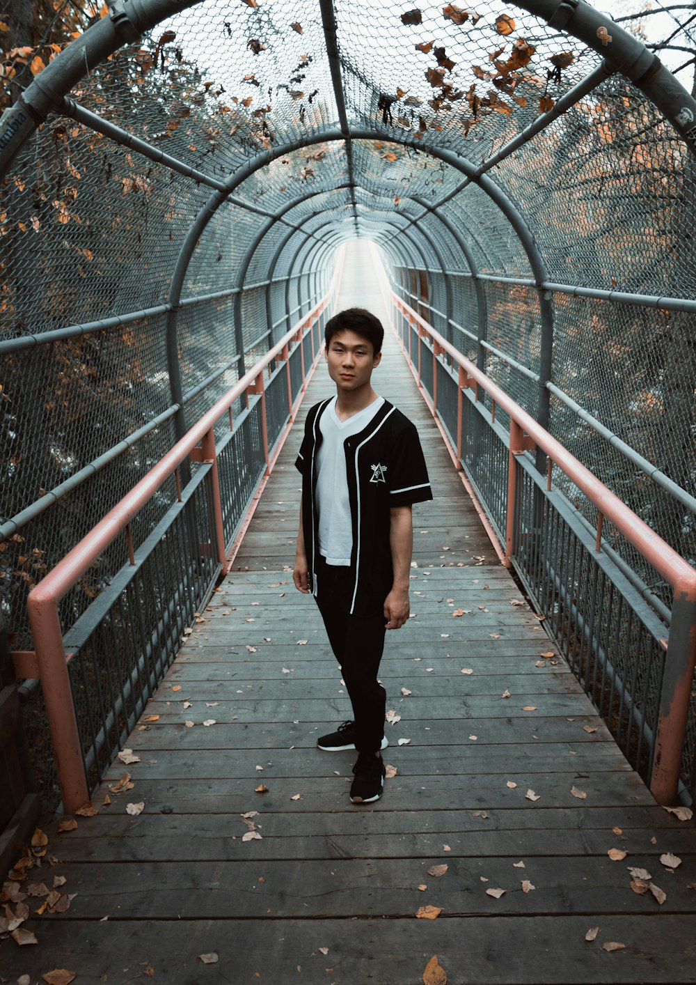 man standing in the middle of a hanging bridge