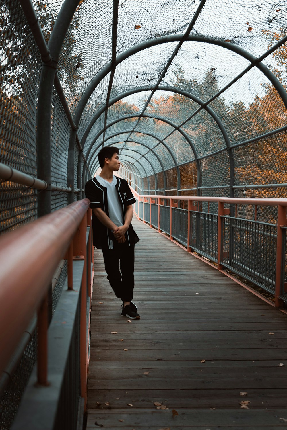 man standing and leaning on handrail