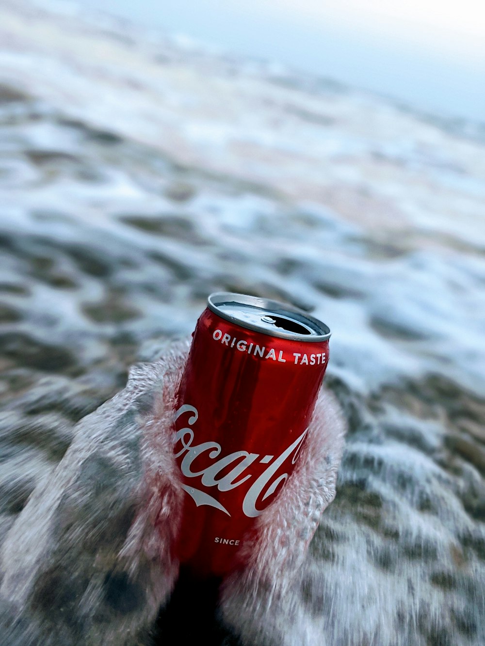 selective focus photography of wave splashing on red Coca-Cola can