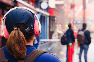 woman wearing pink and white cordless headphones