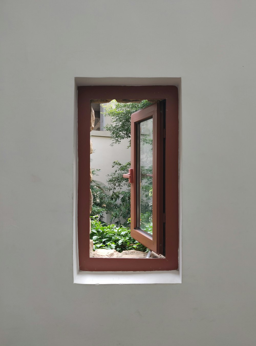 geöffnetes braunes Glasfenster mit Holzrahmen