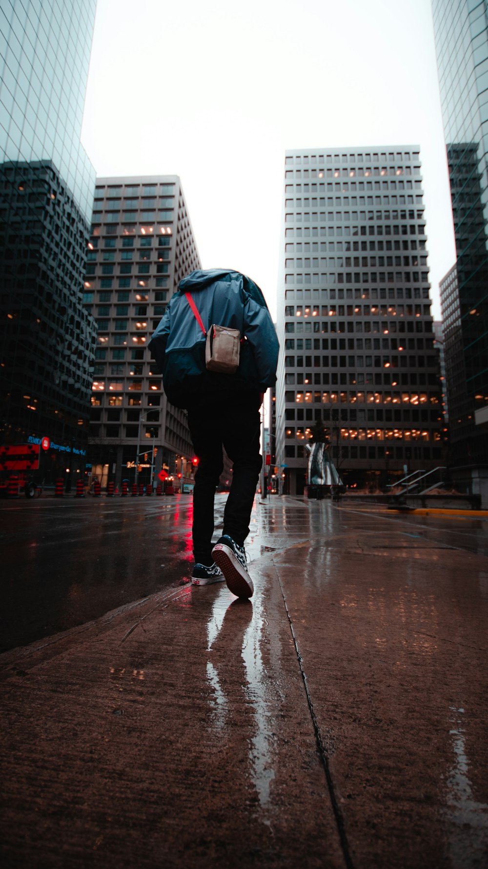 person walking on road near buildings during day