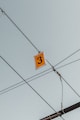 yellow 3 signboard hanging from cable