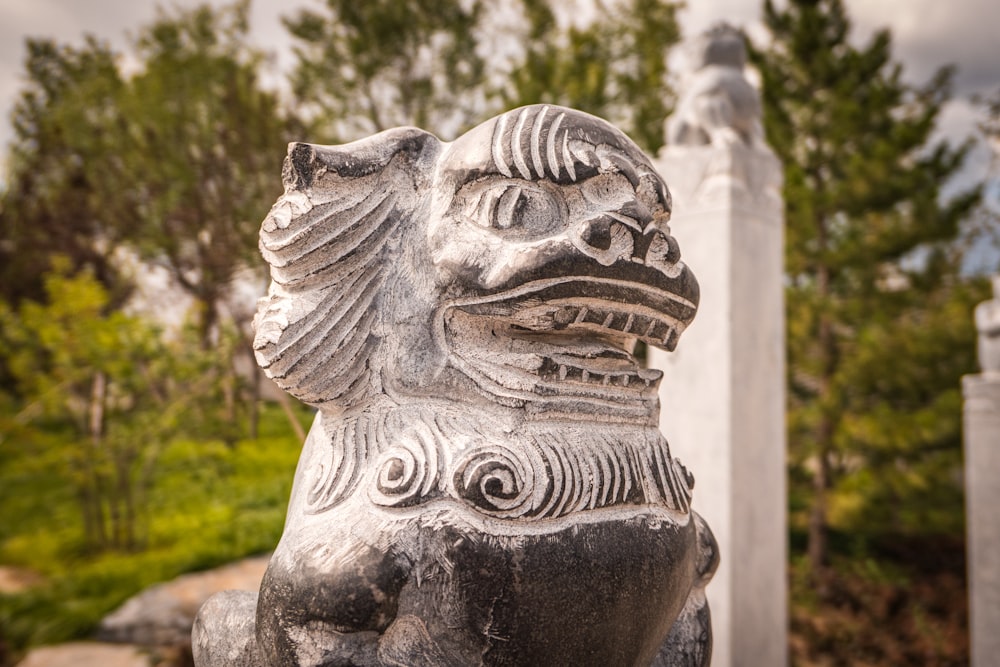 selective focus photography of gray foo dog statue