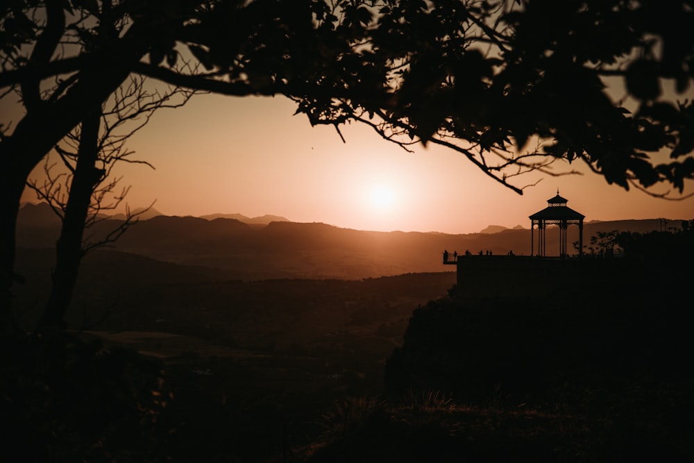 brown gazebo beside mountain during golden hour