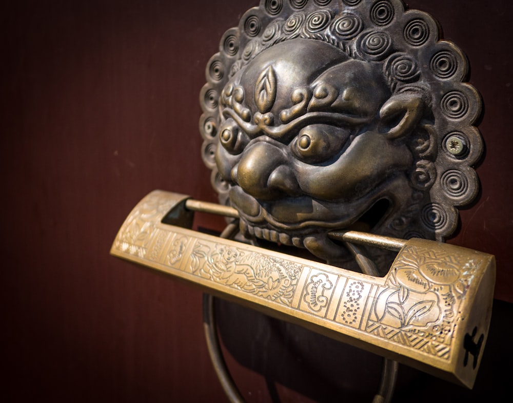 a golden lion head on a metal hook