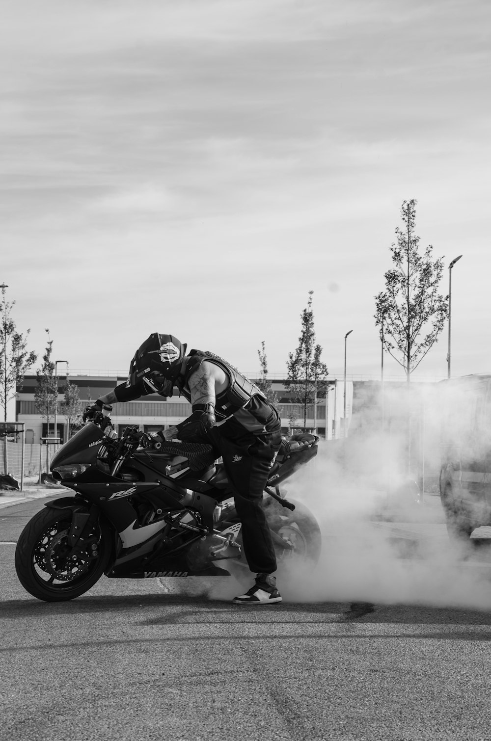 Graustufenfotografie eines Mannes, der ein Motorrad fährt